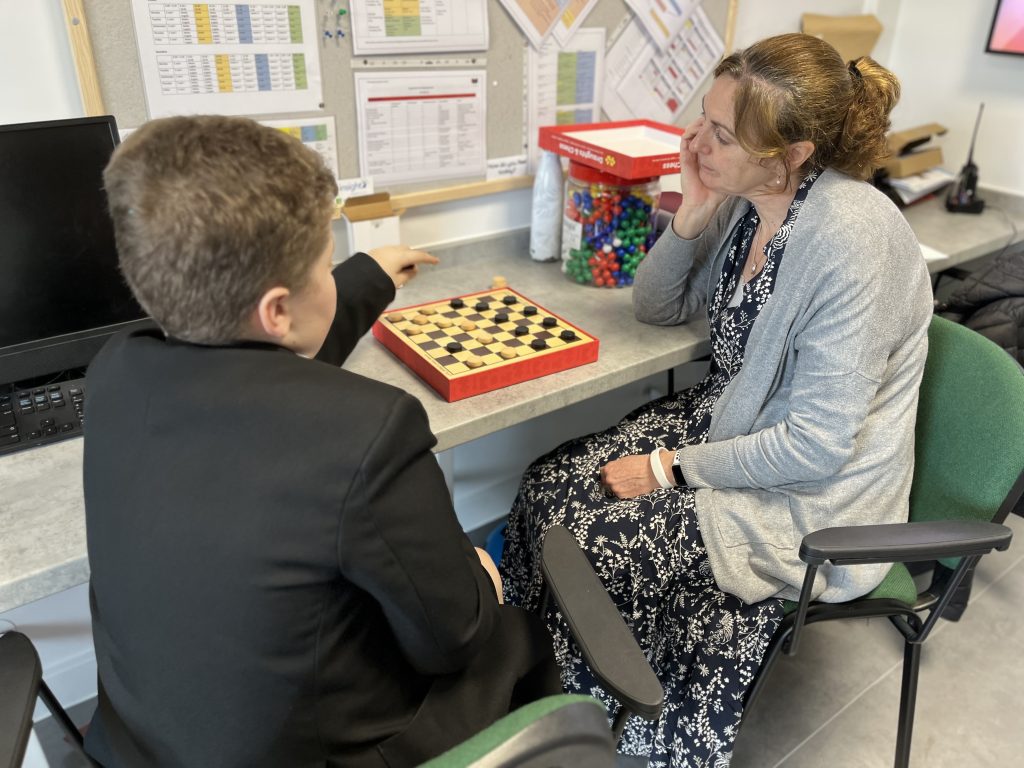 Jo Pettingale playing draughts with a student